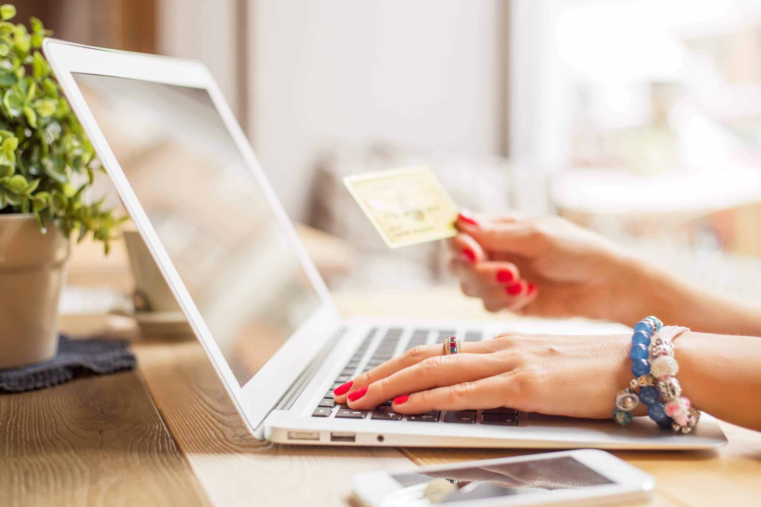 woman on computer paying with card